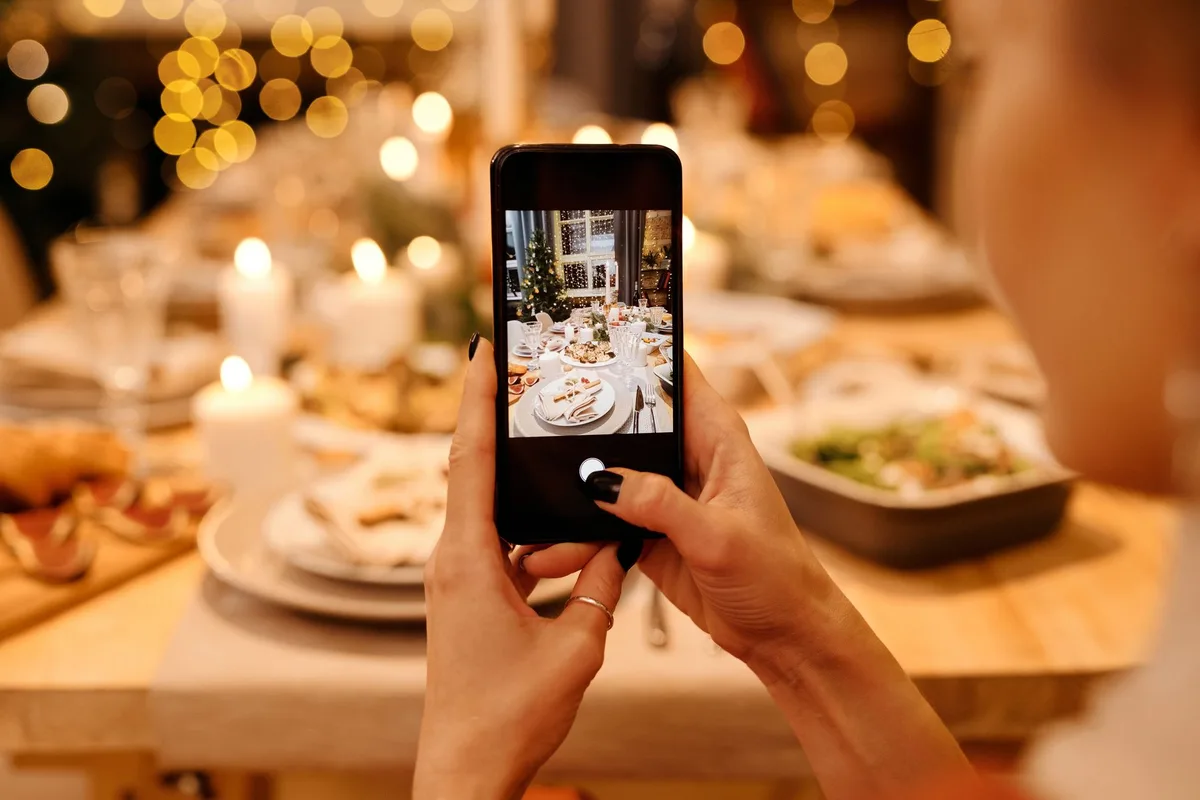 Table de fête avec plats variés, verres et légumes, vue d'une personne qui choisit des aliments sains