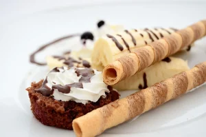 Morceau de chocolat noir sur une surface en bois avec poudre de cacao
