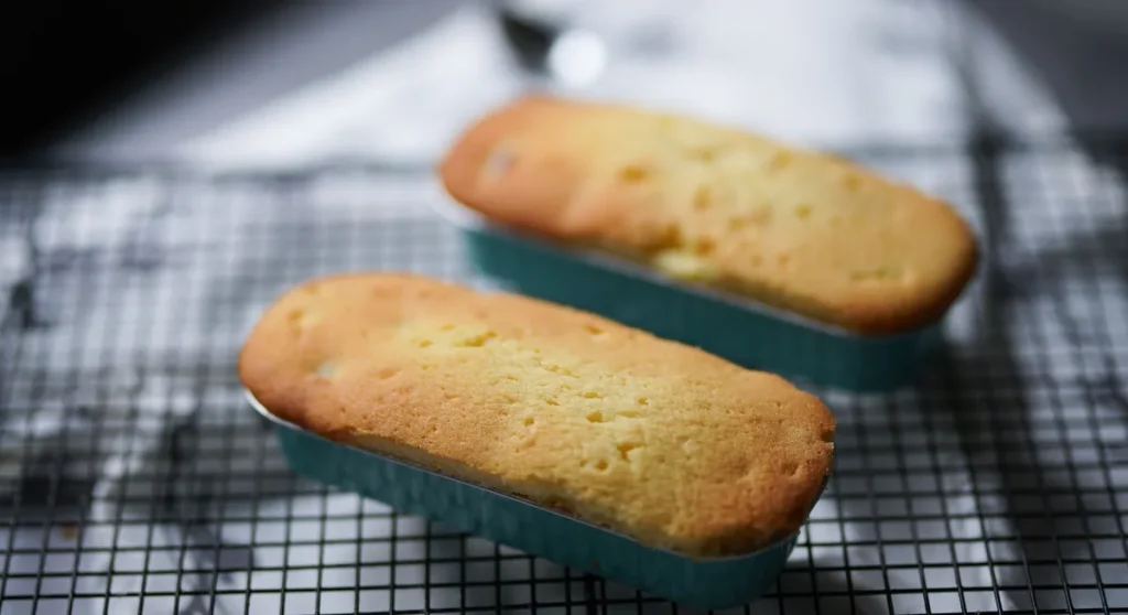 Madeleines dorées fraîchement cuites avec une belle bosse dans un moule en tôle traditionnel