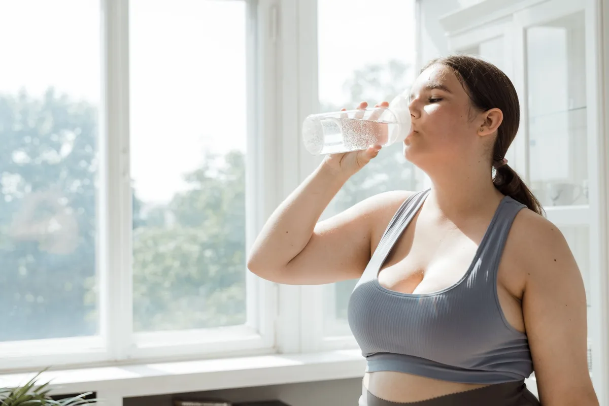 Femme buvant de l'eau pendant une séance d'activité physique
