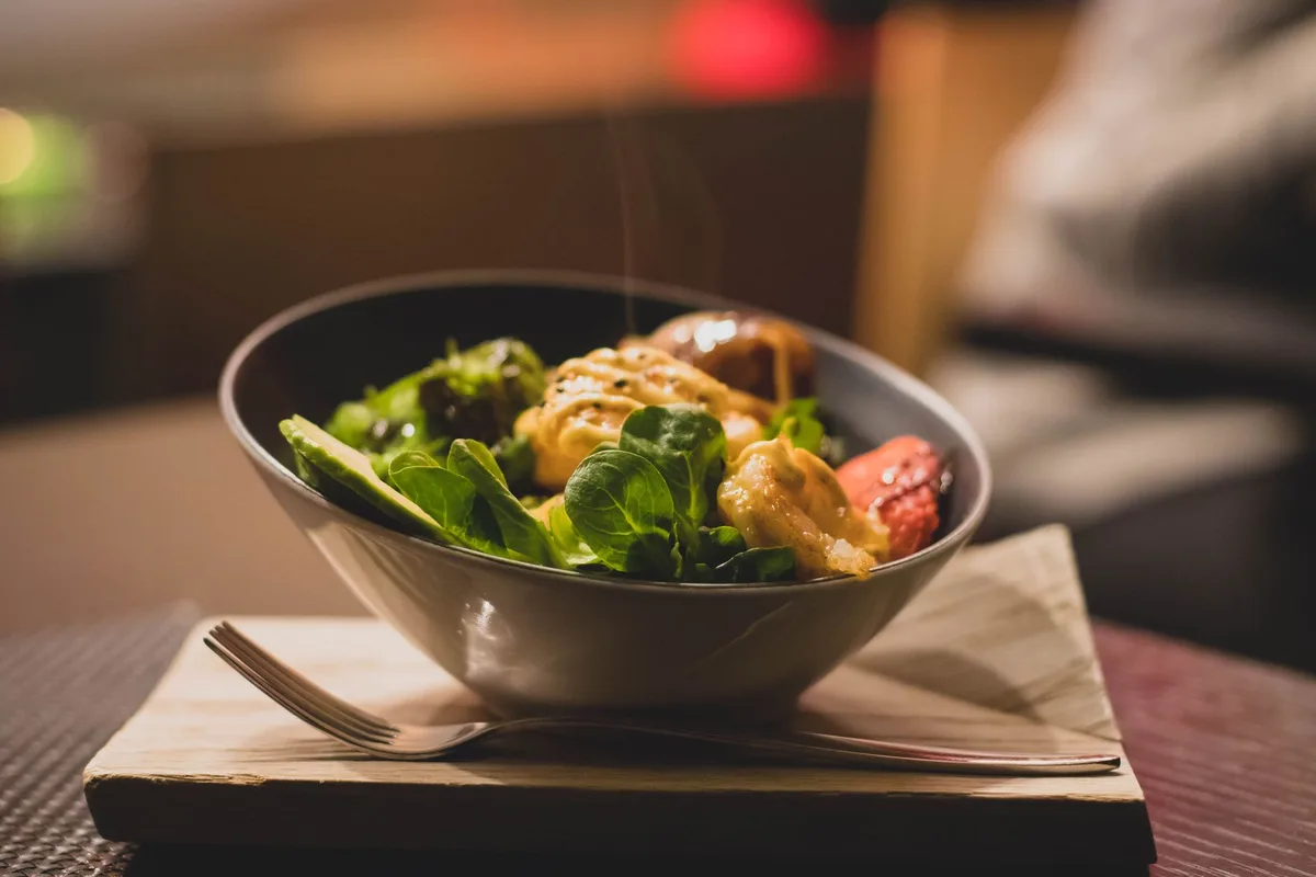 Assiette équilibrée avec aliments nutritifs et verre d'eau, symbole d'une perte de poids saine après l'accouchement.