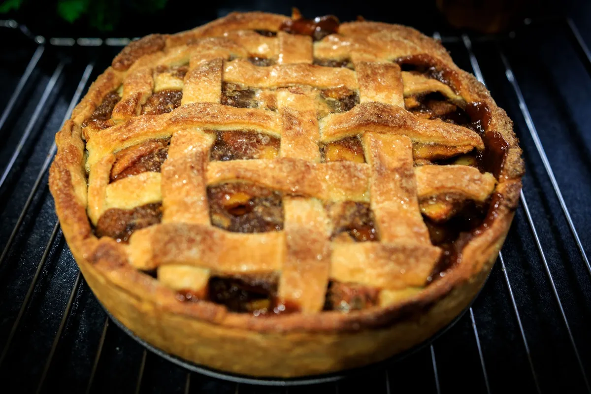Une tarte aux pommes dorée sortant du four, cuite à point