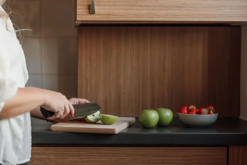 Mains préparant une tarte aux pommes avec des tranches de fruits dorés et de la cannelle