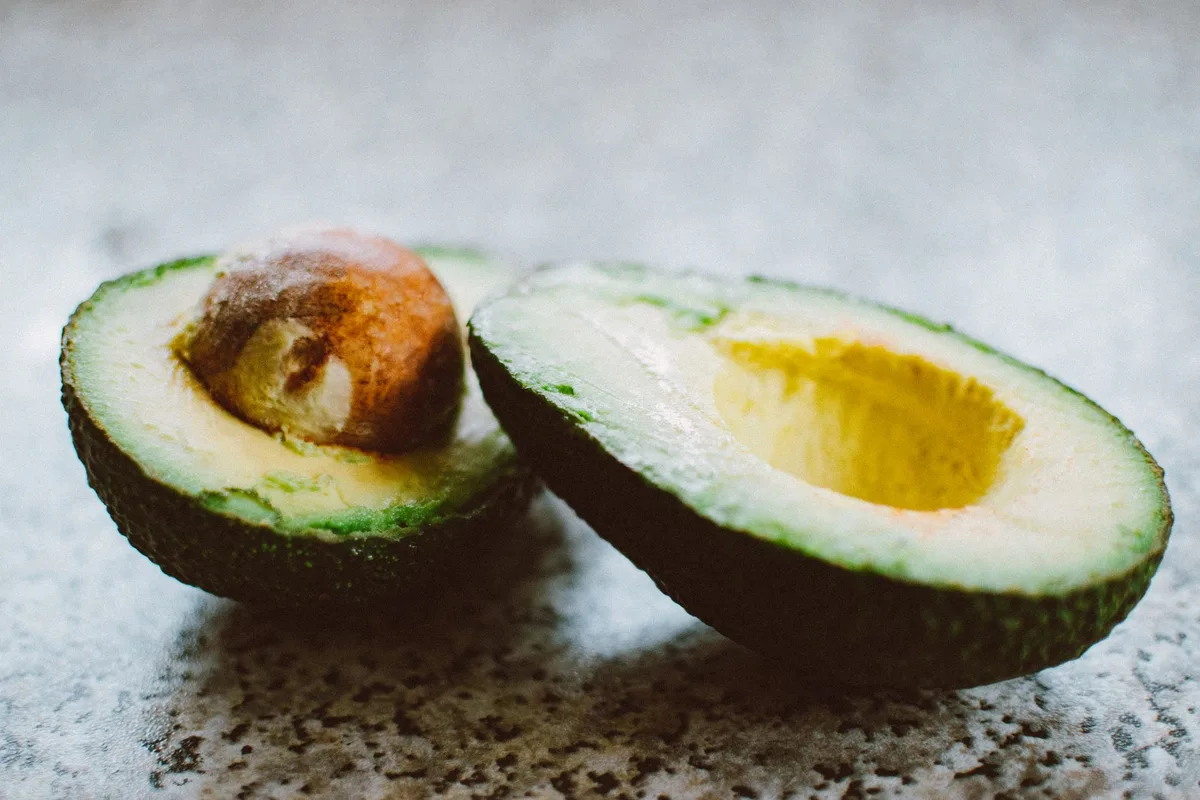 Avocat mûr coupé en deux montrant sa chair crémeuse et son noyau