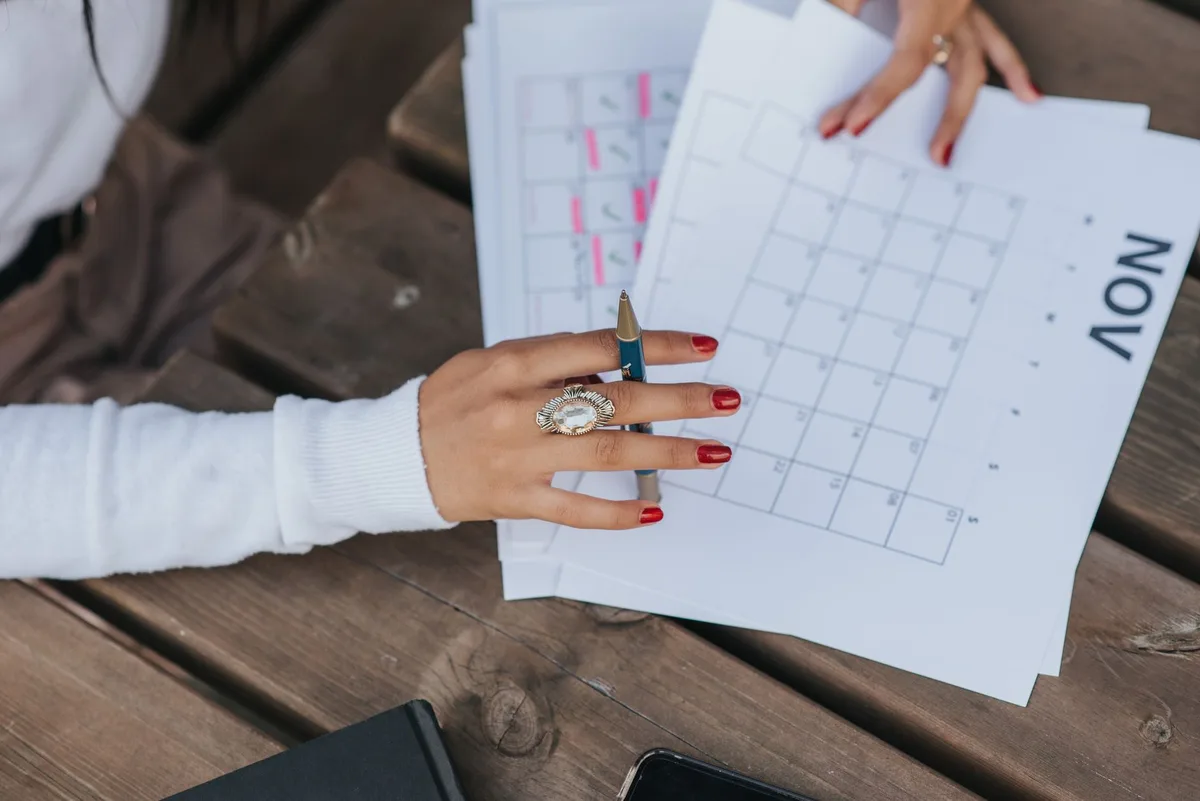 Femme notant ses symptômes dans un journal de suivi avec un calendrier