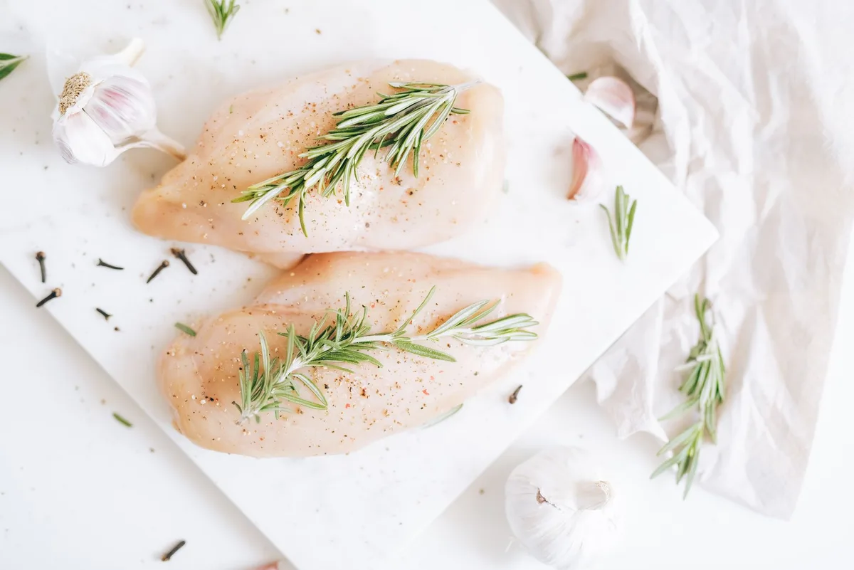 Poulet immergé dans une marinade au vin rouge avec ail, oignons et légumes aromatiques