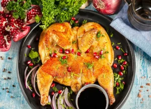 Préparation d'un poulet cru avec du sel, de l'huile et des herbes aromatiques avant cuisson
