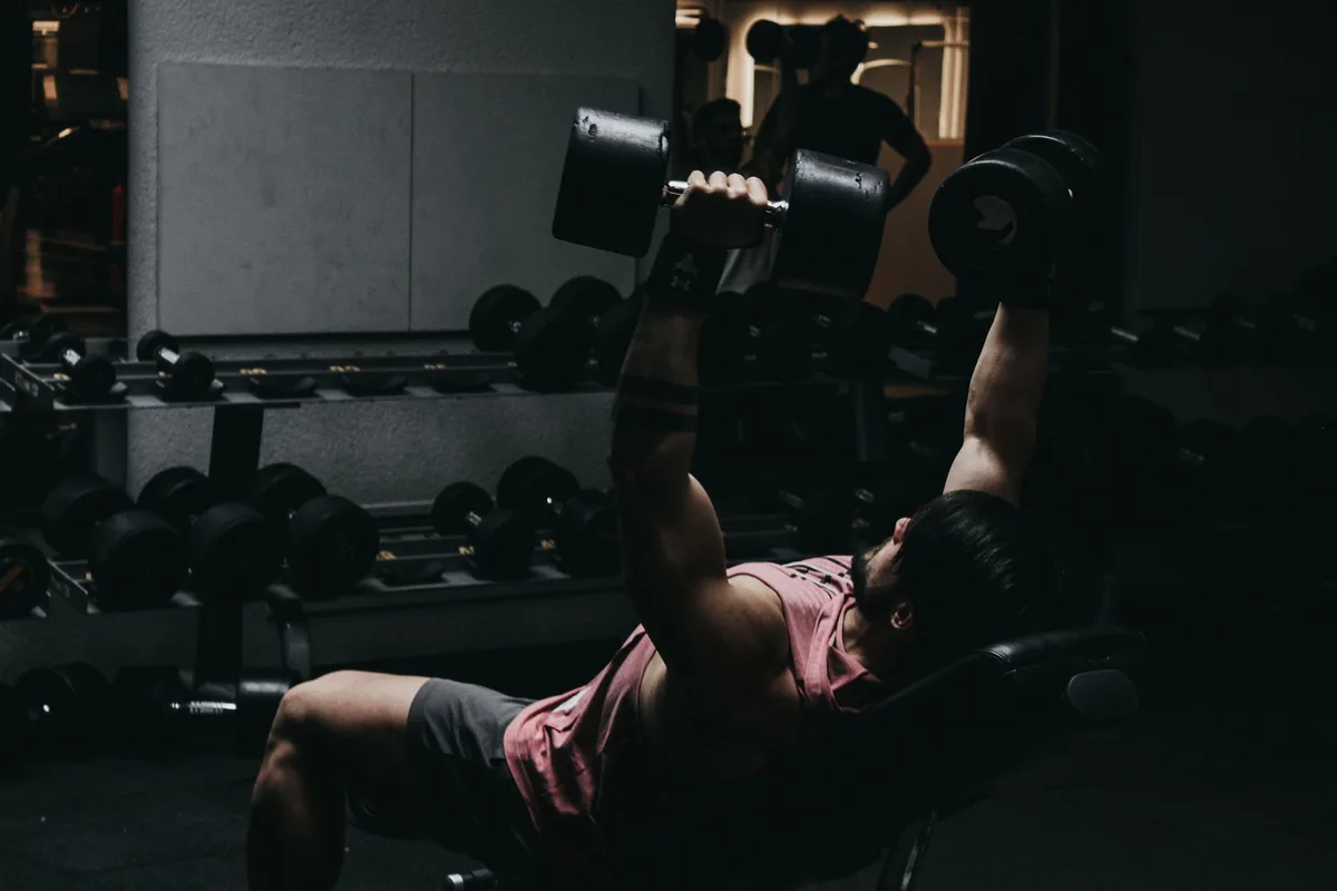 Personne effectuant un exercice de renforcement musculaire intense en salle de sport