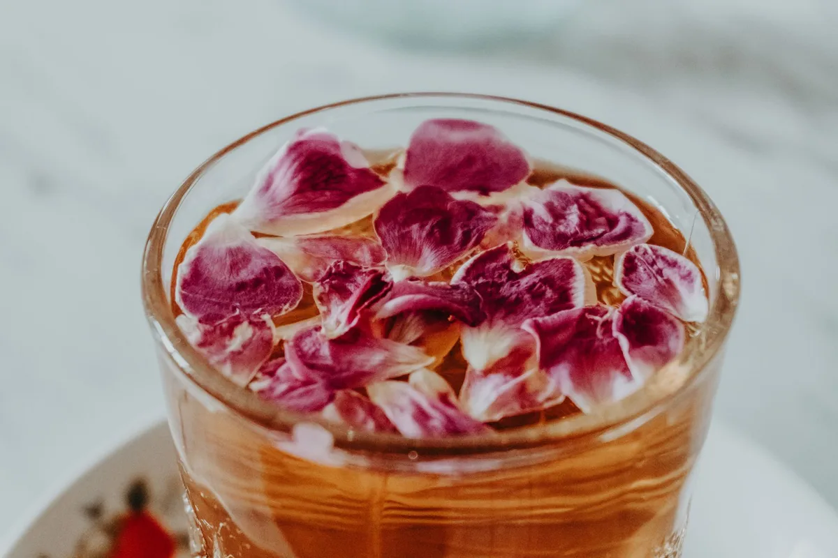 Préparation d'eau de rose maison : pétales de roses dans une casserole avec eau