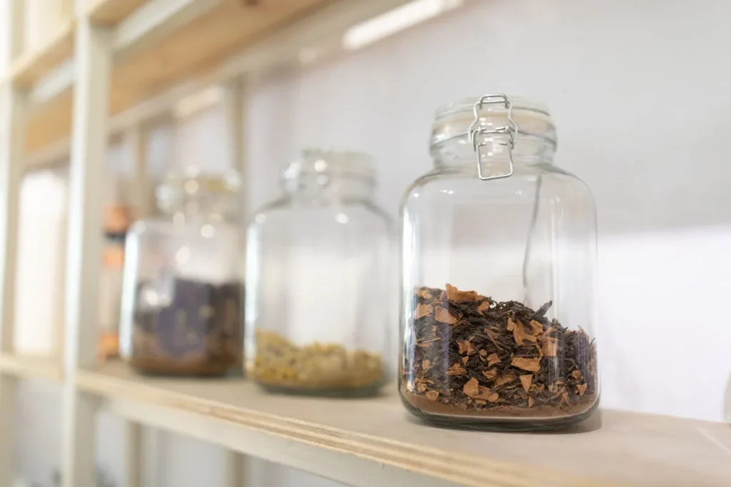 Bocaux d'épices colorées et herbes séchées sur un plan de travail en bois