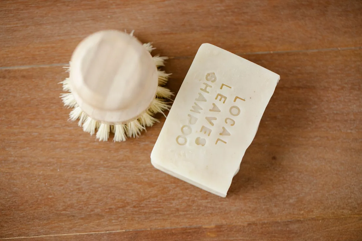 Des produits cosmétiques solides comme le shampoing et le savon rangés dans une petite boîte en métal.
