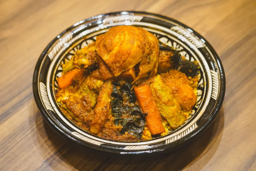 Mains versant des épices dans une casserole avec légumes et huile chaude