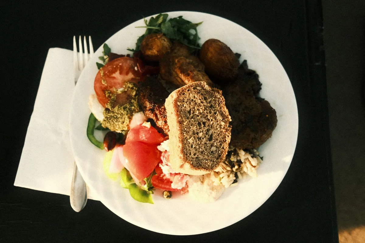 Assiette équilibrée avec légumes frais, fruits et céréales complètes en lumière naturelle