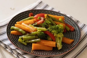 Homme de dos préparant un repas équilibré avec légumes frais et aliments sains à la cuisine