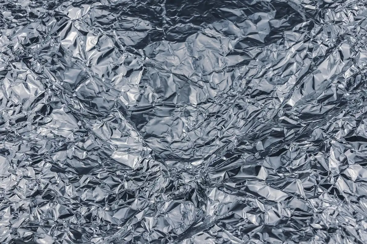 Rouleau de papier aluminium près d'aliments sur un plan de travail