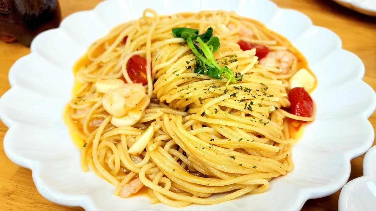 Assiette de pâtes au thon et poivrons colorés, avec ingrédients frais à proximité
