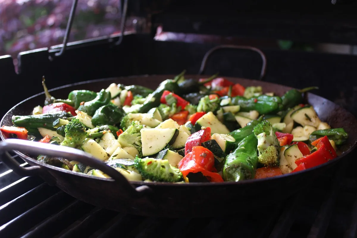 Pommes de terre et courgettes finement coupées dans une poêle dorée à l'huile d'olive