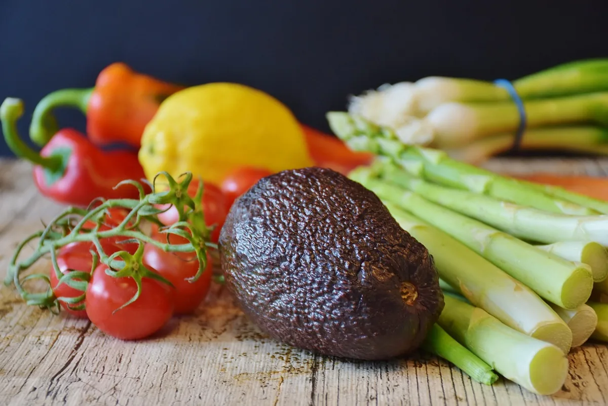 Table de cuisine avec assiette vide et légumes non féculents en arrière-plan
