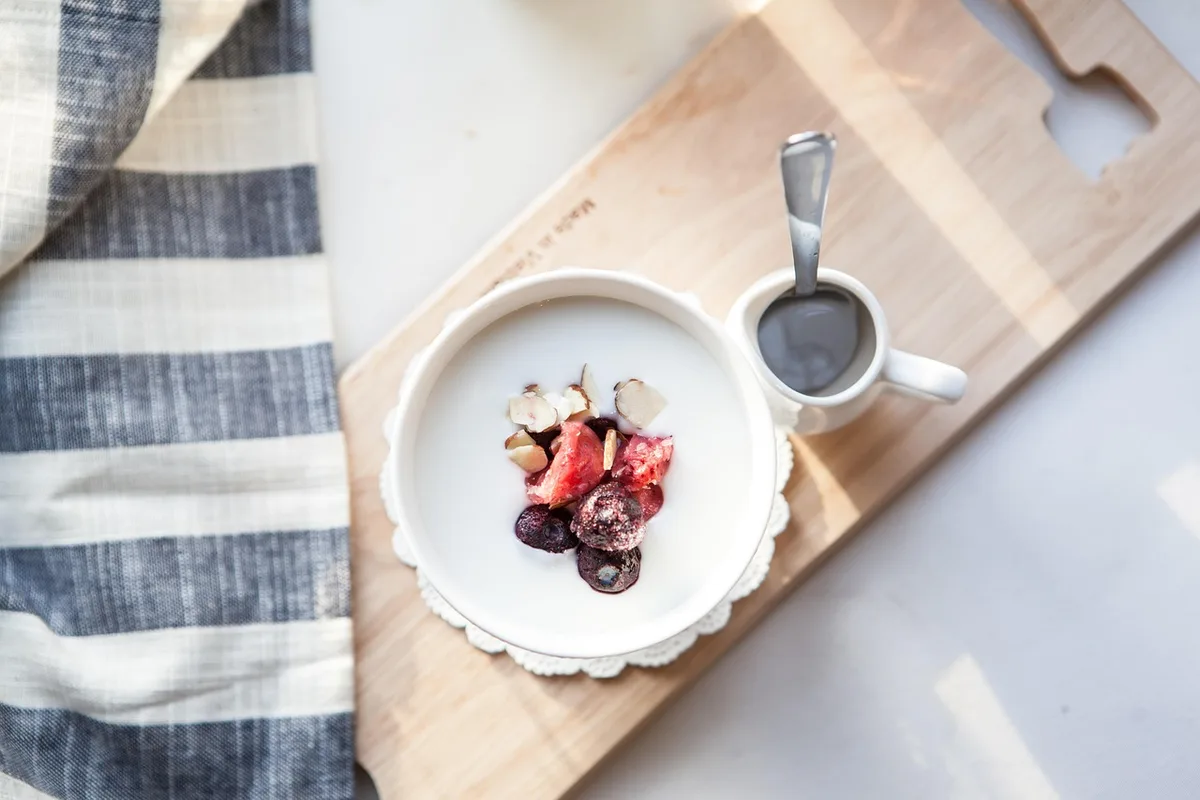 Petit déjeuner sain avec bol de céréales complètes, fruits et oléagineux