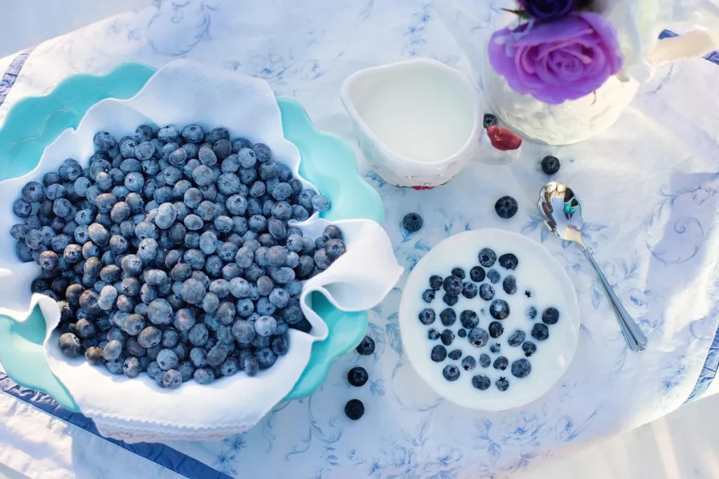 Assiette de fruits entiers et yaourt sur une table en lumière du jour
