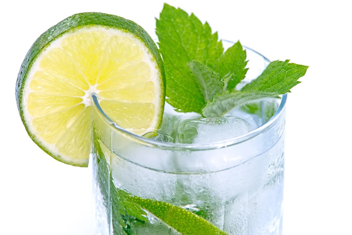 Préparation d'un highball : verser l'eau gazeuse le long des glaçons