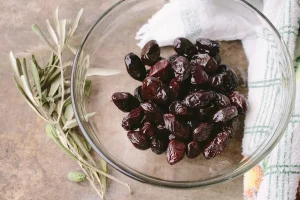 Bol de marinade citron-thym sur un plan de travail ensoleillé, main préparant du poulet