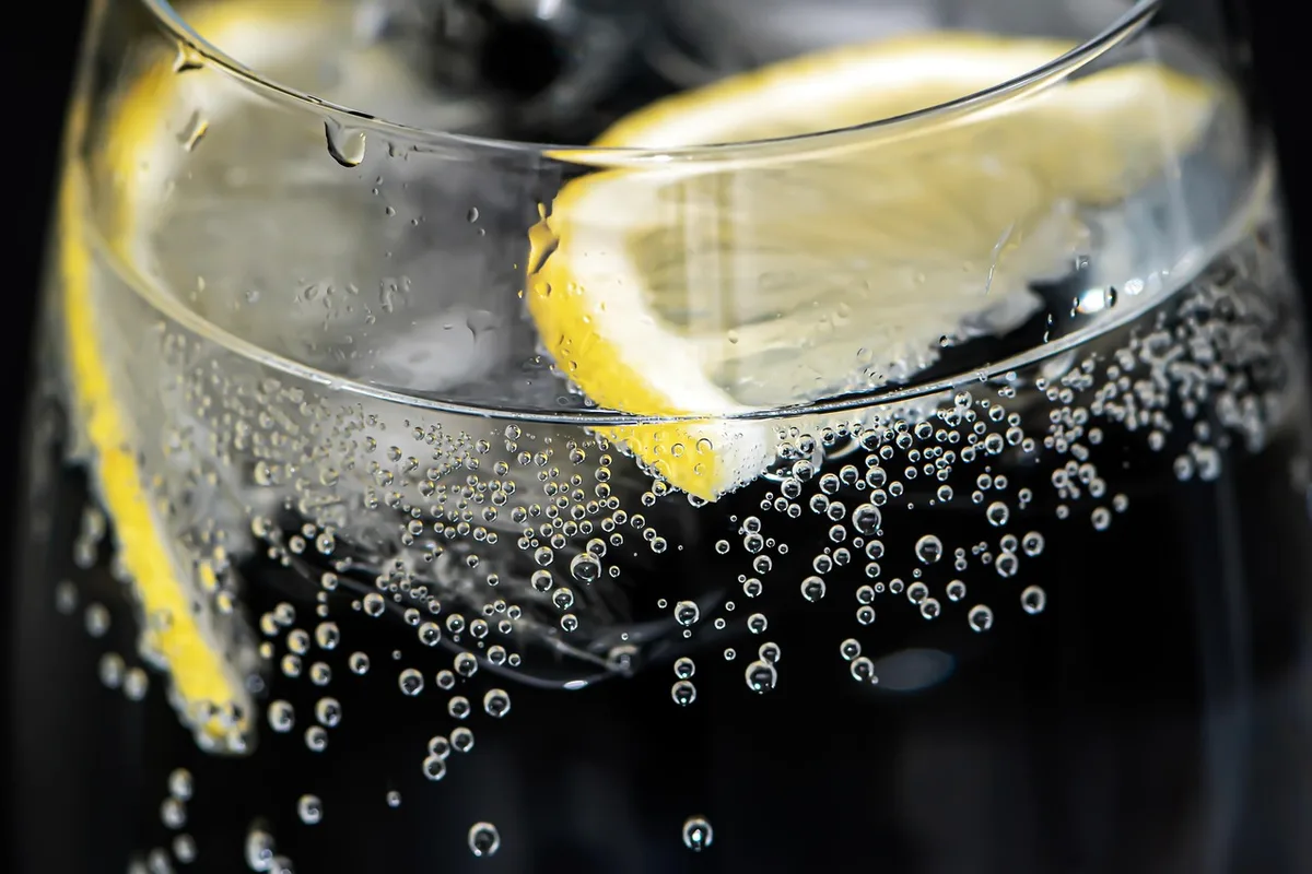 Verre d'eau tiède au citron posé sur une table de cuisine en journée