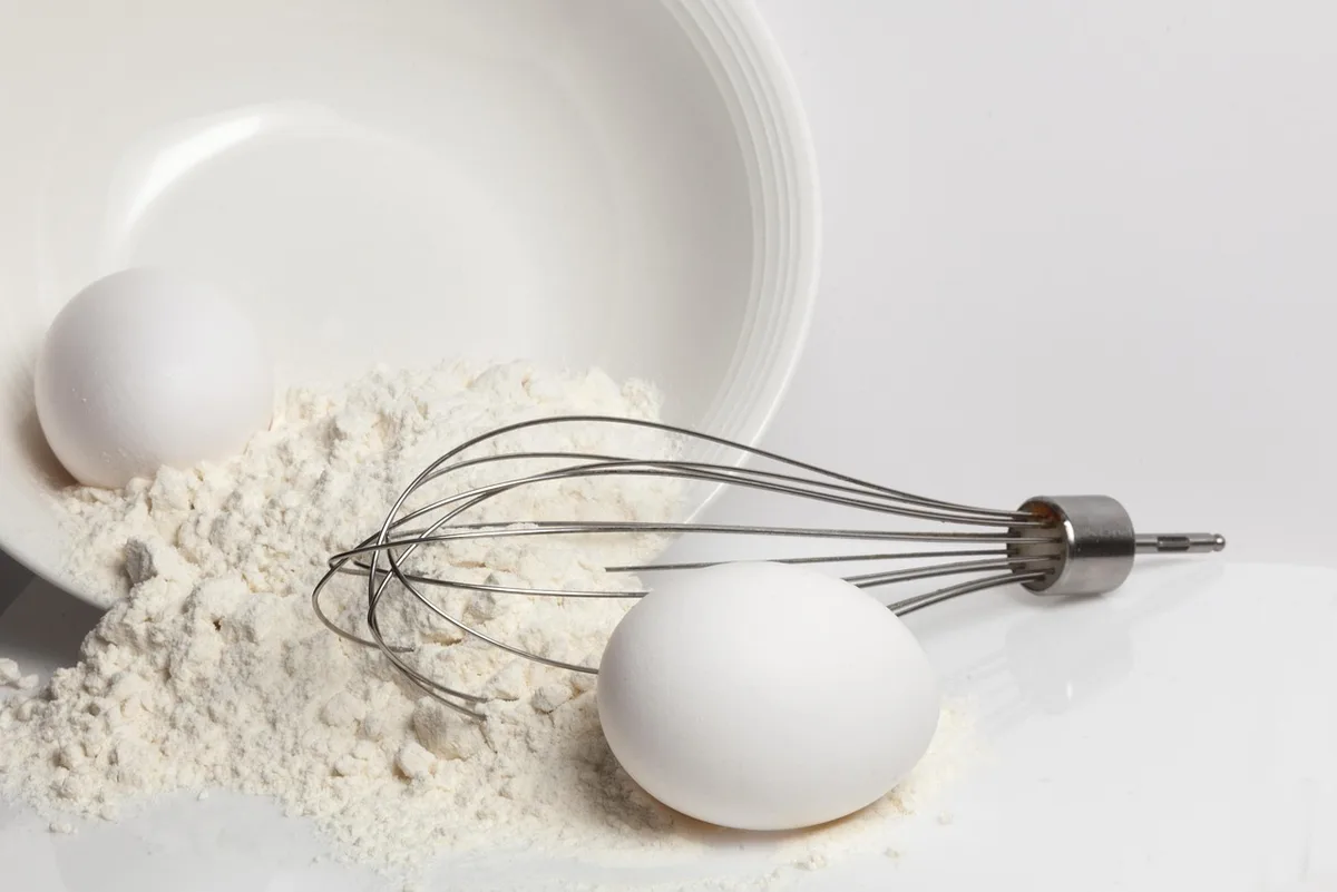 Préparation de la pâte à crêpes dans un bol avec un fouet et du lait
