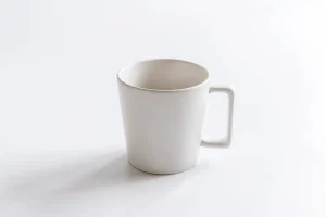 Coin bureau lumineux avec carnet ouvert et tasse de thé près d'une fenêtre en plein jour