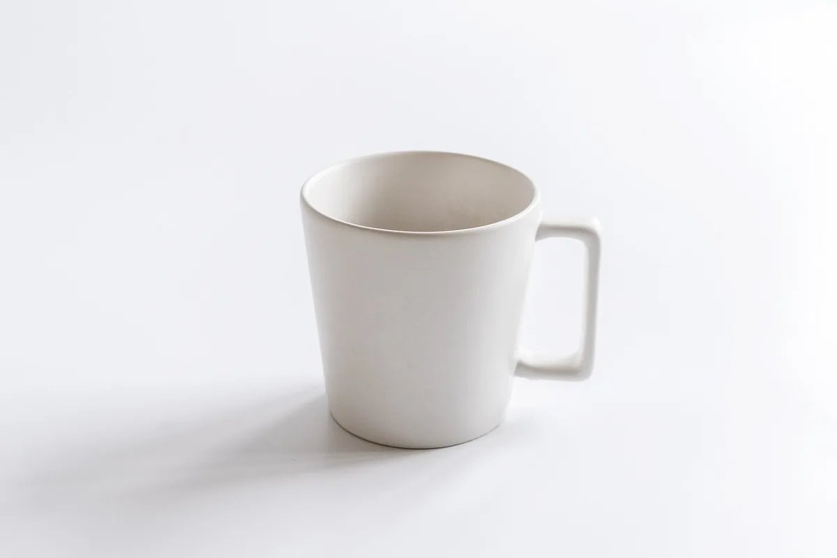 Coin bureau lumineux avec carnet ouvert et tasse de thé près d'une fenêtre en plein jour