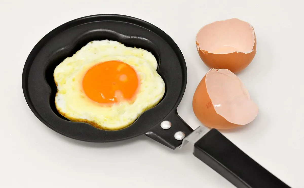 Poêle avec un filet d'huile et graines qui crépitent pendant le tempering